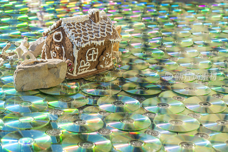 甜蜜的房子在岩石上的贝壳和阳光反射，如在水中的彩色CD/DVD作为纹理背景
